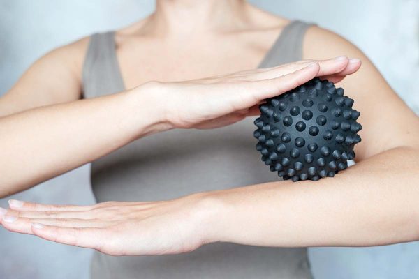 woman massaging her arm with ball